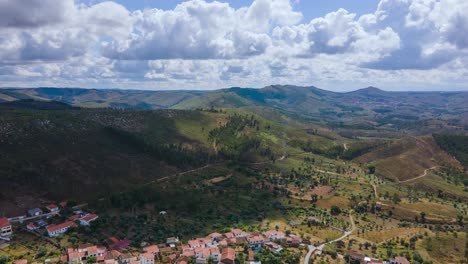 Aerial-hyperlapse-flying-through-a-small-village-surrounded-by-mountains-on-a-beautiful-sunny-cloudy-day