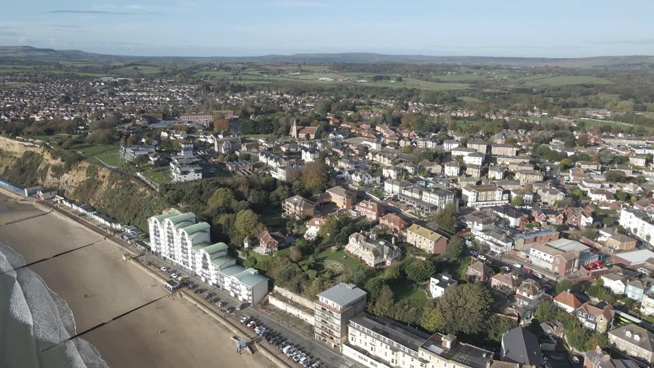 Vista aerea di Sandown, una località balneare e parrocchia civile sulla costa sud-orientale dell'Isola di Wight, in Inghilterra. Drone che ruota verso destra sul mare, mostrando la spiaggia e gli edifici.