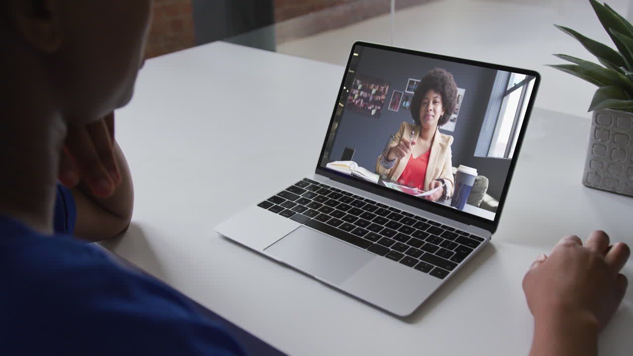 Mid section of african american woman having a video call with female colleague on laptop at office