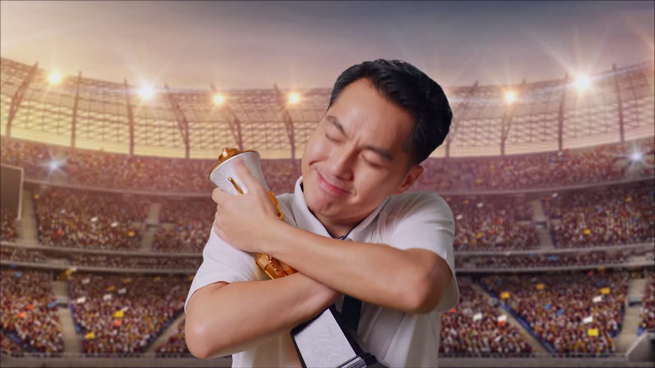 금메달을  아시아 남자가 금 트로피를 안고 경기장에서 첫 우승자로 자부심을 느다.