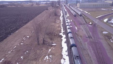 an aerial over an oil train with tanks cars moving rapidly down tracks 1