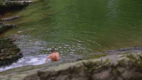 boy sitting at a waterfall