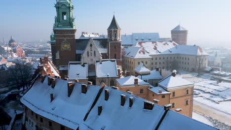 Panorama-of-snow-covered-Wawel-castle-and-Old-Town-at-magic-morning-with-soft-sun-light-during-winter,-Krakow,-Poland