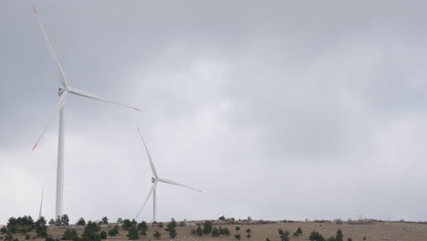 a large wind turbine plant. sustainable and renewable green energy from the wind. turbines arranged on a mountain plateau. windy weather before the storm.