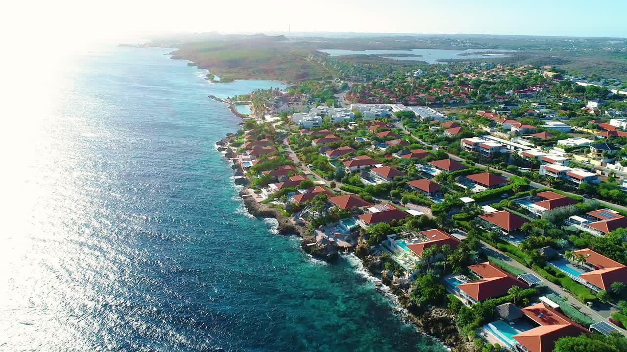 Panoramica aerea con drone di ville di lusso sulla costa di Curaçao, vacanza tropicale all'alba