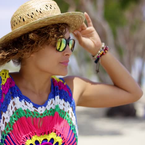 pretty woman in sunglasses adjusting hat