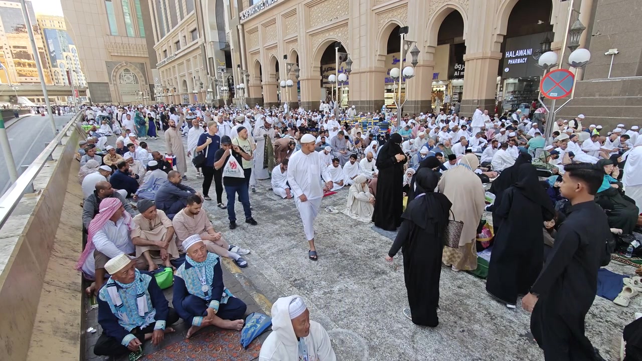 Pellegrini che riposano fuori dalla Grande Moschea alla Mecca