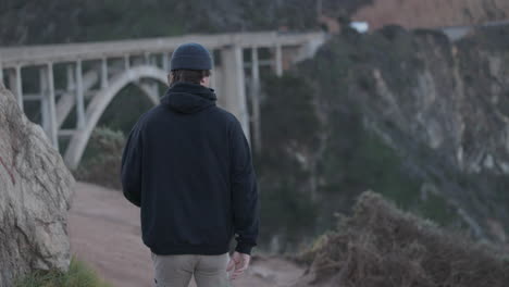 adult male explores bixby bridge in the early morning