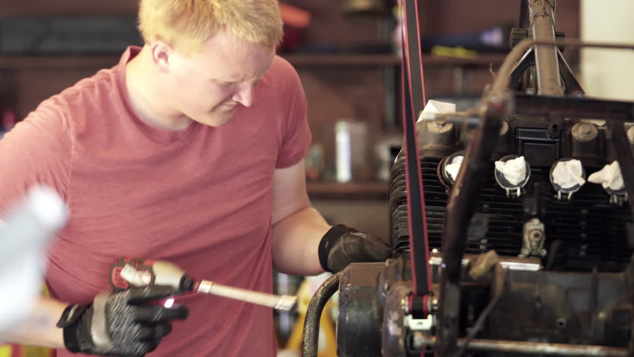 Medium Close Up of Young Blonde Man Using Power Tools During Motorcycle Teardown