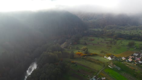 picturesque countryside of transylvania, romania seen through the low clouds over the mountains and rivers, aerial view