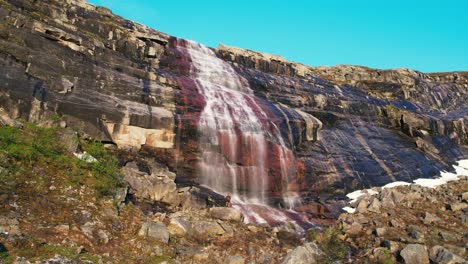 Vista-Aérea-De-La-Cascada-Que-Cae-En-Cascada-Por-La-Roca-De-Color-Rojo-En-El-Parque-Nacional-De-Hardangervidda