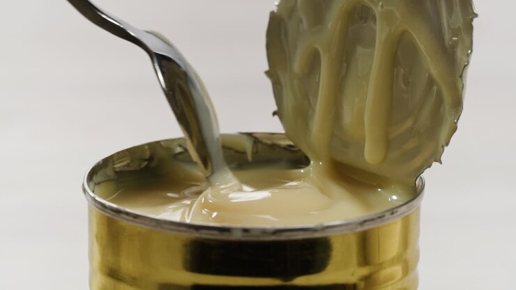 leckere kondensmilch, löffel und waffeln auf hellgrauem tisch, flach gelegt. platz für text. hochwertiges 4k-filmmaterial