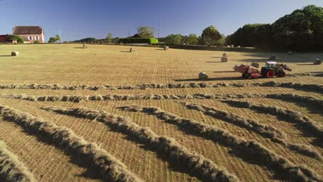 aerial view of tractor harvesting straw bales.