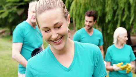 Female-volunteer-holding-recycle-bin-in-the-park-