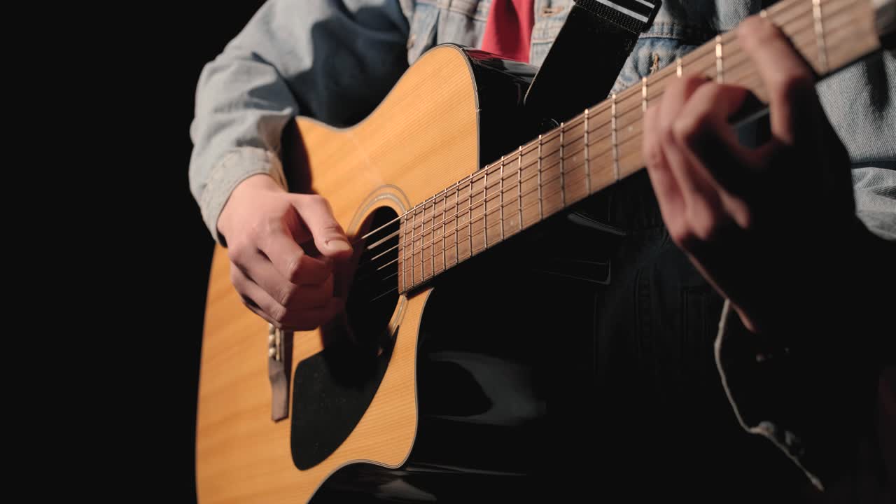 한 뮤지션이 큰 무대에서 기타를 연주하고 있으며, 관객들은 배경에 불을 들고 있습니다. 관객실은 아름다운 박이는 불빛으로 가득 차 있습니다.