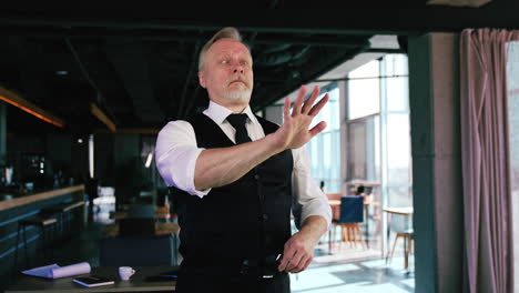 smiling man puts off the glasses and mimes as though he can't see. adult man grimacing in office.
