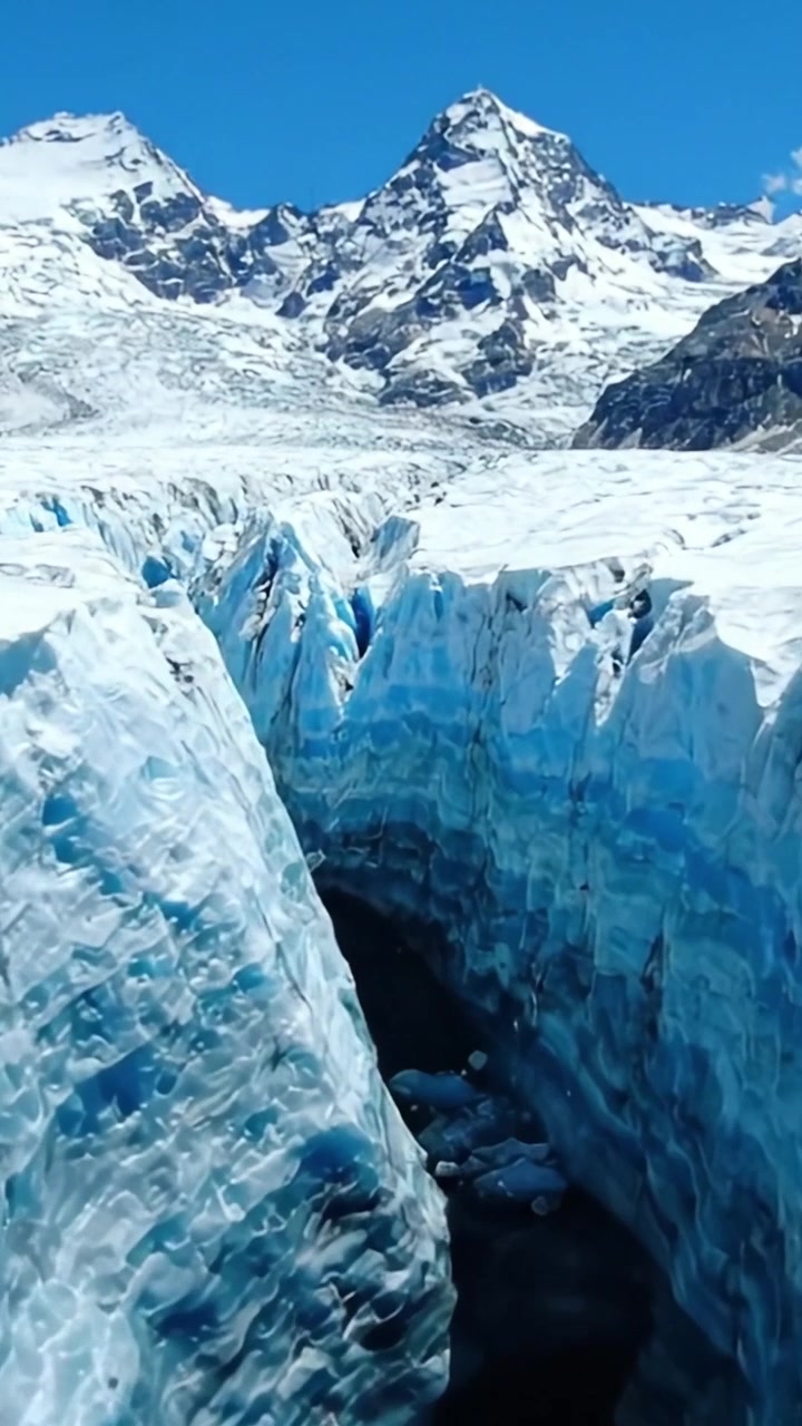 Atemberaubende Gletscherlandschaft: Eine wunderschöne Aussicht auf majestätische Eisrisse und schneebedeckte Gipfel unter einem klaren blauen Himmel in alpiner Umgebung.
