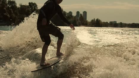 Wake-surfer-enjoy-evening-waves.-Close-up-of-rider-surfing-waves-at-sunset