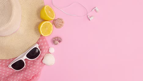 summer trendy beach accessories with copy space frame on pastel pink background. stop motion flat lay