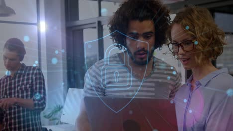 Animation-of-security-padlock-icon-and-blue-spot-over-diverse-man-and-woman-discussing-at-office