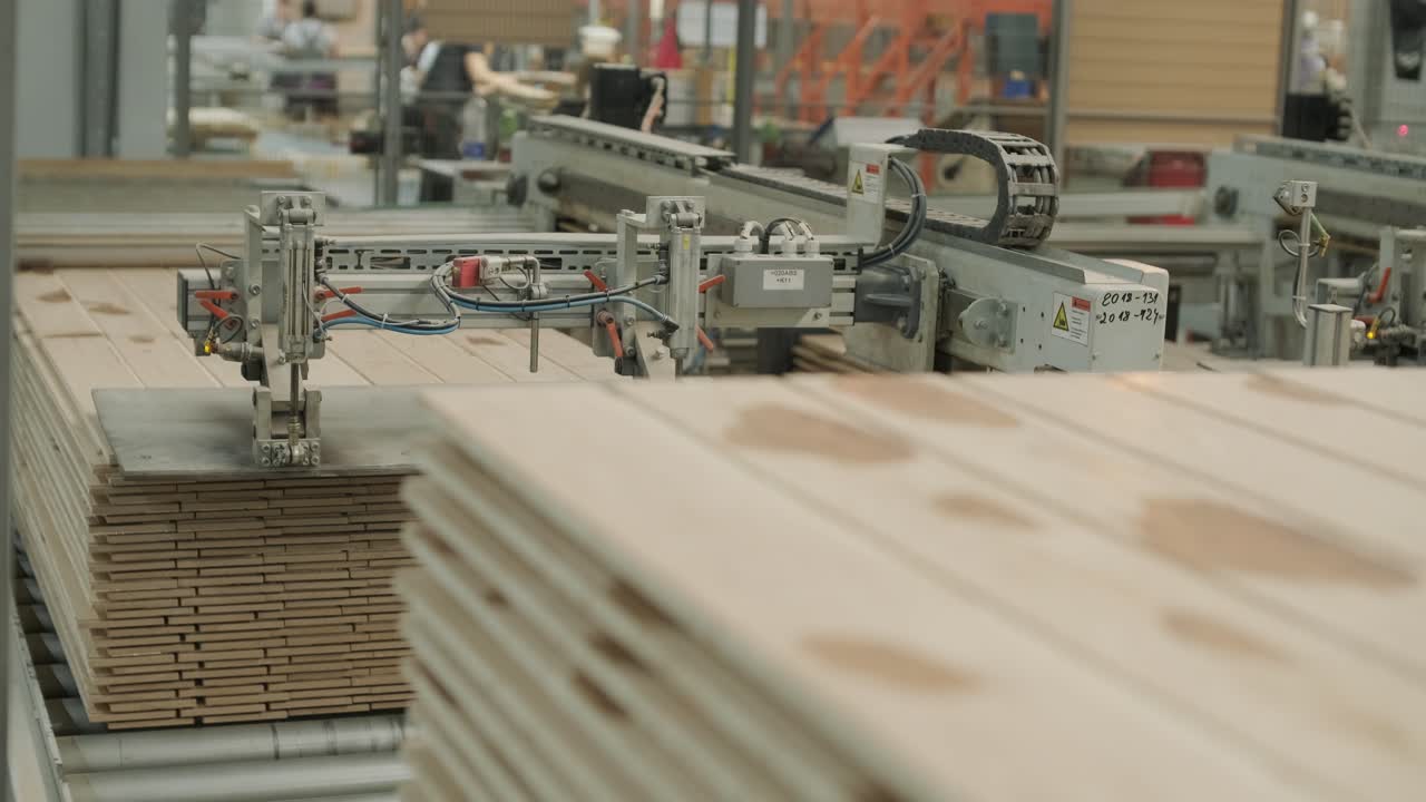 Macchina automatizzata che impila assi di legno in una fabbrica.