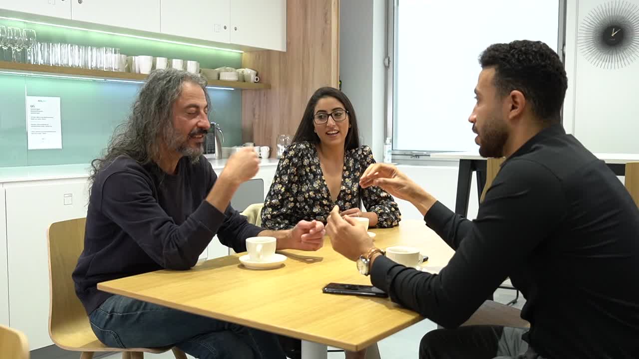 People having a conversation at a table in an office