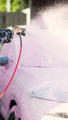 woman washing a car at a self-service car wash