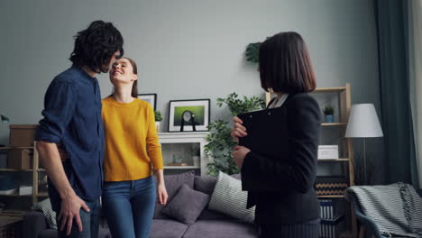 couple receiving house keys from real estate agent