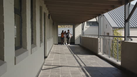 multiracial students walking together in school hallway, enjoying conversation, copy space