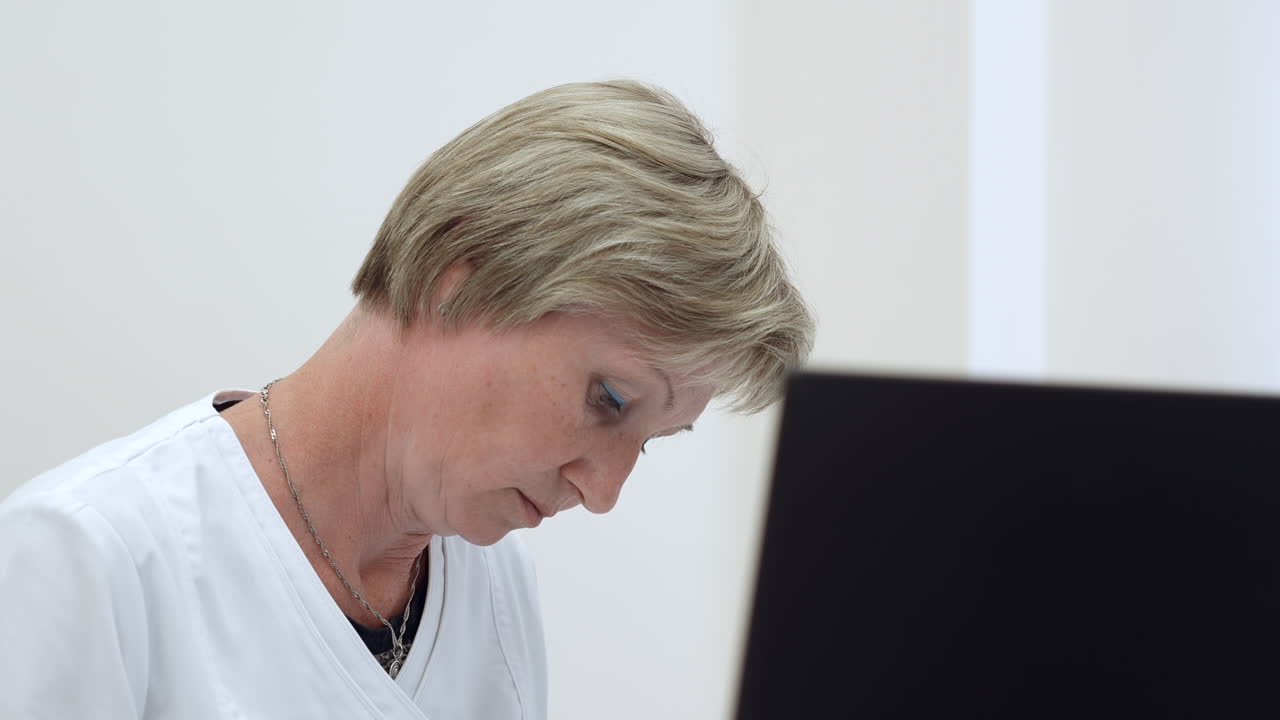 mujer médica trabajando en una computadora portátil