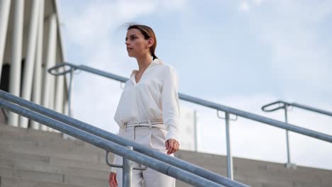 a businesswoman goes down the stairs and looks around