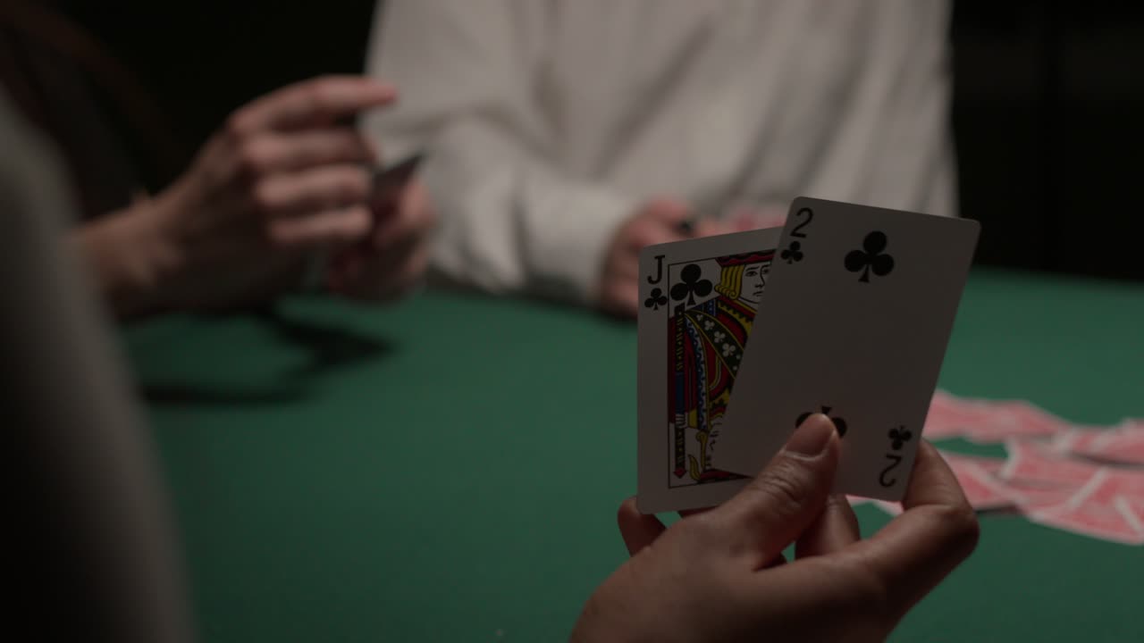 la jugadora saca dos cartas y luego las vuelve a poner en un oscuro casino malhumorado