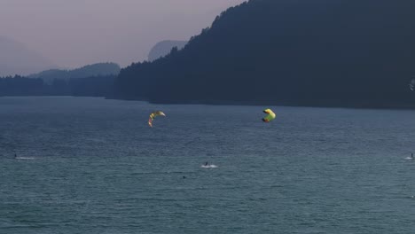 peaceful lake view with paragliders flying above the water and scenic mountains