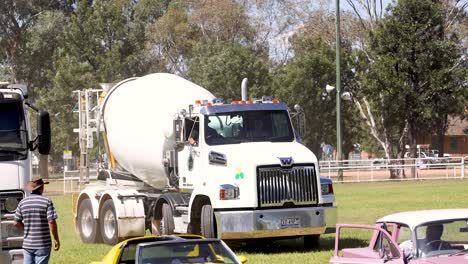 cement mixer truck drives past a public park