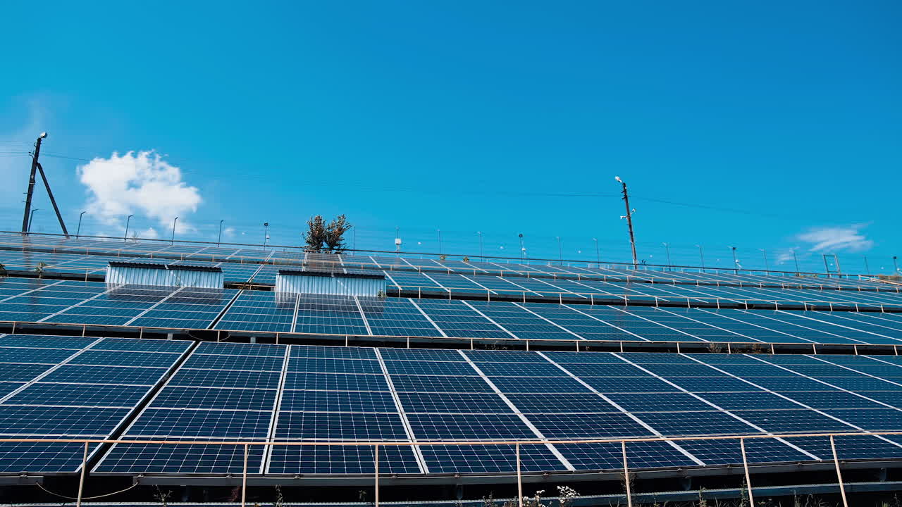 Photovoltaic solar panels at an angle. New solar energy farm. Sunny batteries on blue sky background at sunlight. Production of clean energy.