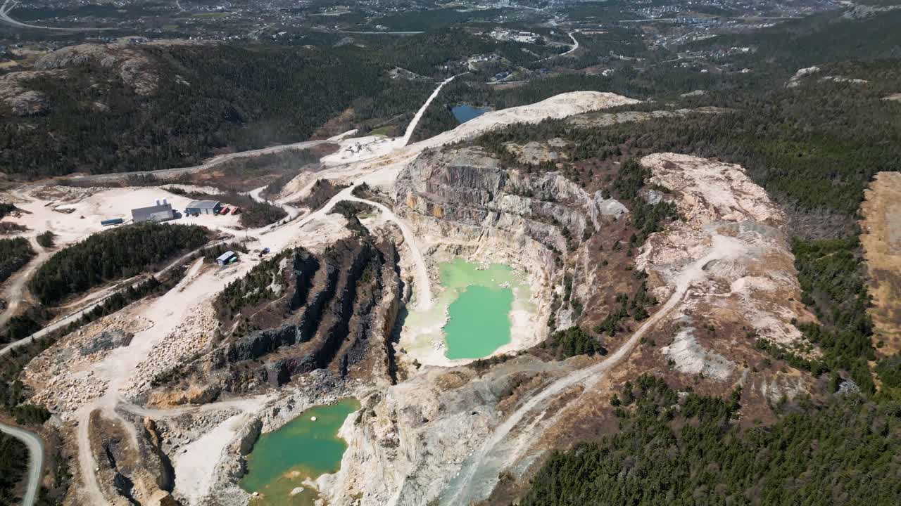 Drone shot of an open talc (pyrophillite) mine in Manuels, Newfoundland, Canada displaying Conception Bay South in the background