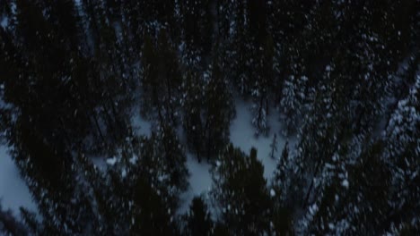 Aerial-forward-pan-up-shot-of-a-snowy-mountain-overlooking-the-horizon