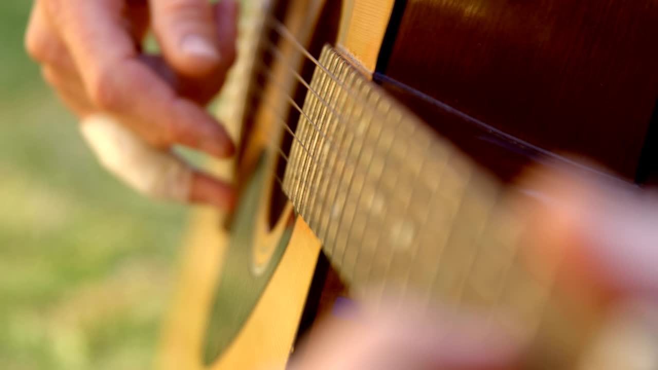 Man playing guitar in the garden 4k