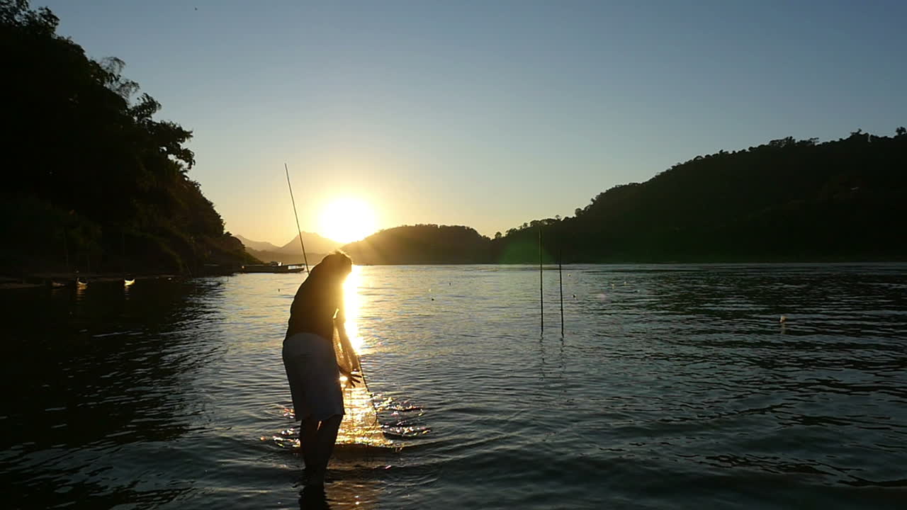 Man fishing at sunset on a river