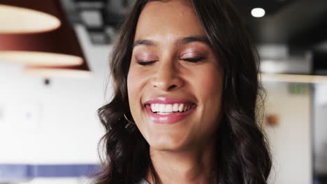 Portrait-of-happy-biracial-casual-businesswoman-in-office,-slow-motion