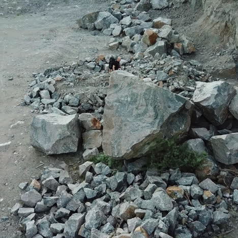 hiker man going through the stone trail and comes into a rocky place. aerial view of a tourist trekking in the mountains outdoors.