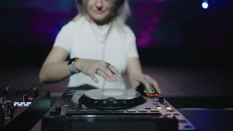 female dj mixing music on a turntable