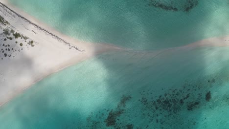 Aerial-top-down-view-of-clouds-passing-over-sandbar-surrounded-by-turquoise-water