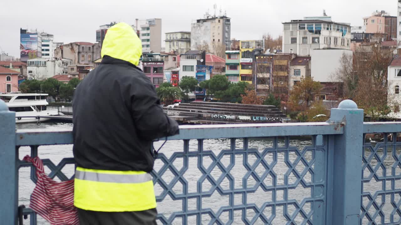 Un uomo in piedi su un ponte che osserva un paesaggio urbano
