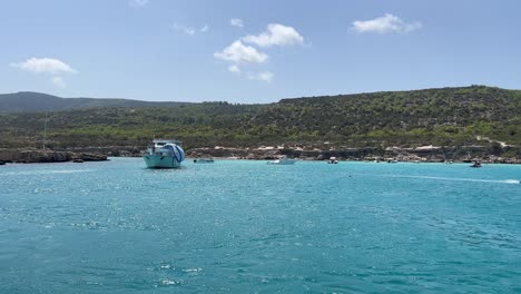 Beautiful-turquoise-water-at-Mediterranean-sea-in-Paphos-filmed-from-boat,-up-close-establish-shot