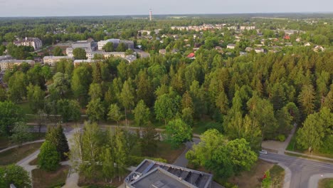 Forest-greenery-and-small-town-of-Sigulda-in-Latvia,-aerial-view