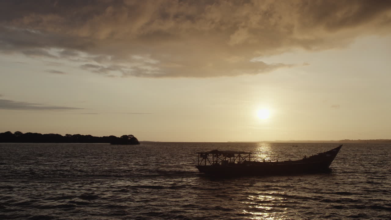 Wide shot of a boat navigating at sunset in Colombia's Pacific Coast