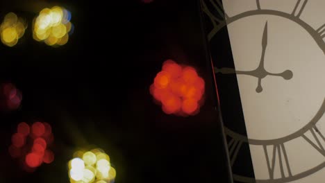 outdoor christmas decorations lantern with clock overlay, blured christmas lights flashing in background, closeup