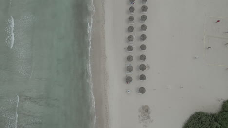 beautiful 4k drone footage soaring above a tranquil, empty sandy beach in majorca.
