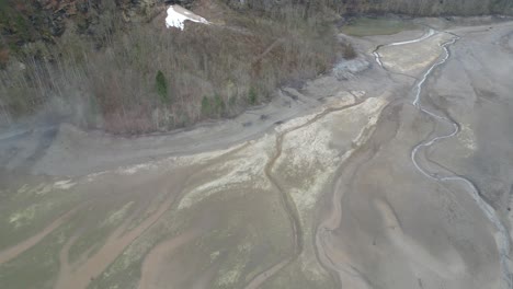 The-dried-up-river-flows-into-the-Klöntalersee-lake-in-Glarus,-Switzerland